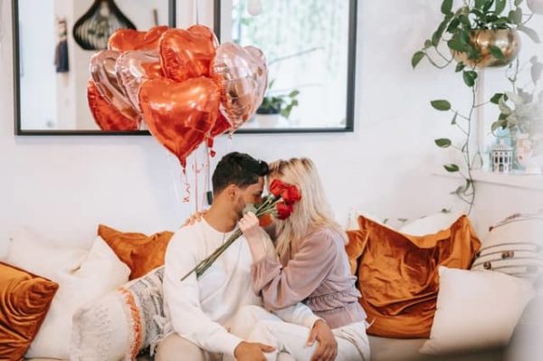 Couple célébrant la Saint-Valentin avec des ballons et des roses rouges